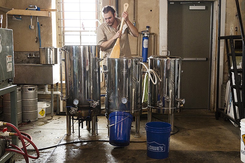  Jacob Scarlock stirs wort, one of the building blocks of beer, with extra water to make sure all of the sugars and flavor are rinsed from the mash before moving the wort to the kettle for boiling Wednesday, Mar. 23, 2016 at Pecan Point Brewing. Scarlock's grandfather made the paddle for the brewery out of unfinished cypress. 