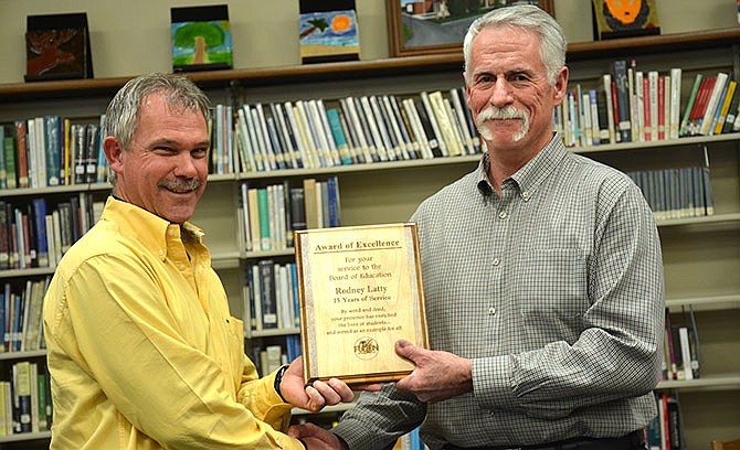 Fulton Board of Education member Andy Bonderer (left) presents an award of excellence to outgoing board member Rodney Latty, who served the district for 15 years.