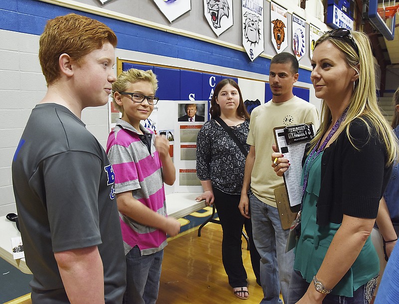 Heather Fees, right, and Jeremy Gerling, second from right, ask students questions about the decisions theyâ€™ve made as a political party and how they came to their conclusions Friday during an exhibit at South Callaway Middle School. Tanner Vaughan, left, Raife Evans, second from left, and Amber Egly formed the Wolf Party whose slogan was â€œWe bite, we fight, we work for your rights.â€