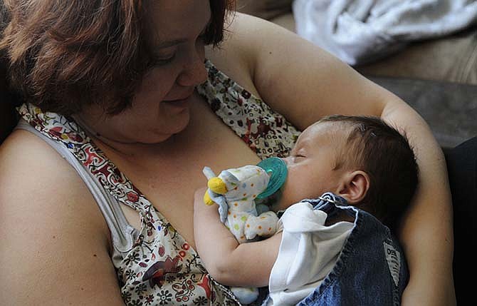 Brandice Nittler, of Holts Summit, Mo., holds her 6-week old baby, Gabriel, as he falls a sleep for a nap. Nittler, a mother of two, decided to breastfeed her firstborn, a now-3-year-old girl, for financial reasons and continued to breastfeed because of the health benefits.
