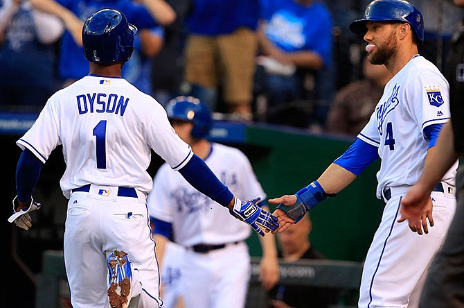 Kansas City Royals' Jarrod Dyson (1) and Alex Gordon (4) celebrate after scoring on a single by teammate Alcides Escobar during the second inning of a baseball game against the Detroit Tigers at Kauffman Stadium in Kansas City, Mo., Tuesday, April 19, 2016. 