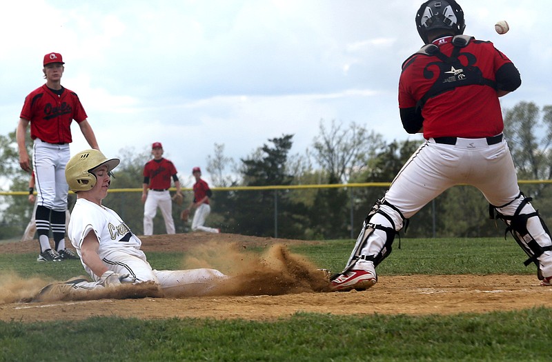 Landon Harrison of Helias slides home for the gameâ€™s first run in Tuesdayâ€™s game against Marshall at the American Legion Post 5 Sports Complex.
