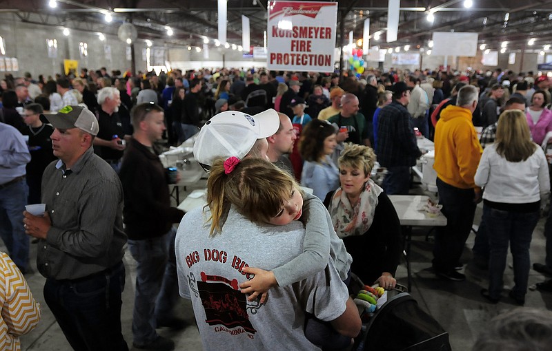 Andrew Stokes carries his daughter, Gracelynn, during the annual Capital City Cook-off Buck-A-Bone BBQ Rib Competition and Fundraiser.