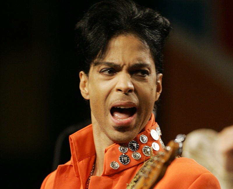 In this Feb. 1, 2007, file photo, Prince plays his guitar during a press conference at the Miami Beach Convention Center in Miami Beach, Fla. Prince's publicist confirmed Thursday, April 21, 2016, that Prince died at his home in Minnesota. He was 57.