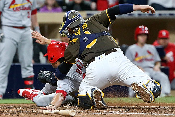 St. Louis Cardinals' Aledmys Diazis is tagged out at home by San Diego Padres catcher Derek Norris during the seventh inning of a baseball game Friday, April 22, 2016, in San Diego.