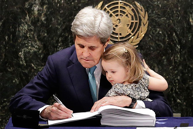 U.S. Secretary of State John Kerry holds his granddaughter Isabel Dobbs-Higginson as he signs the Paris Agreement on climate change, Friday, April 22, 2016 at U.N. headquarters.