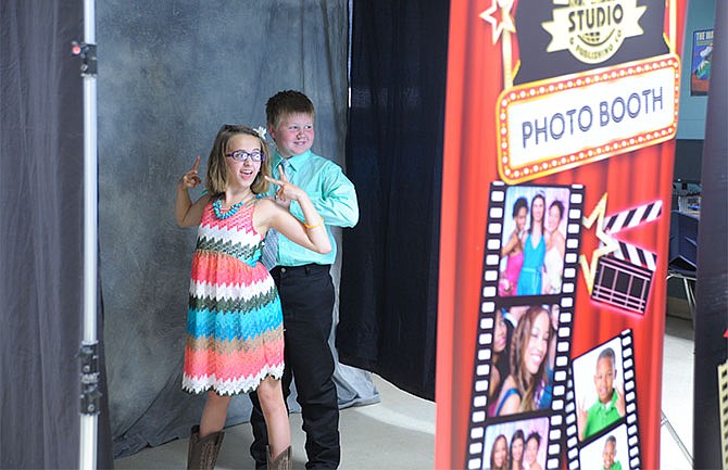 Savannah Smith and Travis Prettyman, both fifth-graders from California, Mo., had a good time in the photo booth during the annual junior high dance Friday in High Point, Mo.