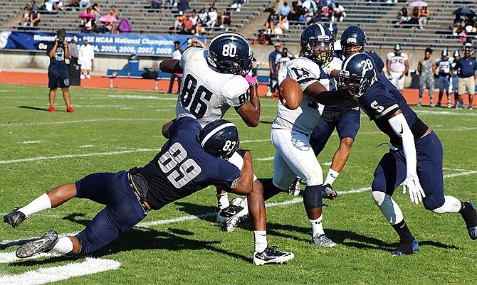 Anthony Price (89) puts a hit on Justin Kelly (86), forcing a fumble during Saturdayâ€™s Spring Game for the Lincoln
Blue Tigers at Dwight T. Reed Stadium.