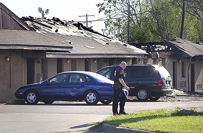 A Topeka police officer looks back at the scene Sunday at the Country Club Motel, in Topeka, Kansas, where two deputy U.S. marshals and one FBI agent suffered gunshot wounds as they tried to arrest a robbery suspect late Saturday night.