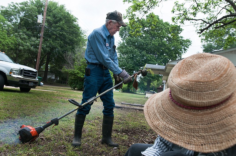 Buddy Burleson, center, works on getting a weed trimmer started while doing yard work with his wife Euline Burleson at a rental property they own Tuesday, April 26, 2016 in Texarkana, Texas. "We're ready to get the hard work done so we can take off in our RV to the lake to take it easy, Said Buddy Burleson. 
