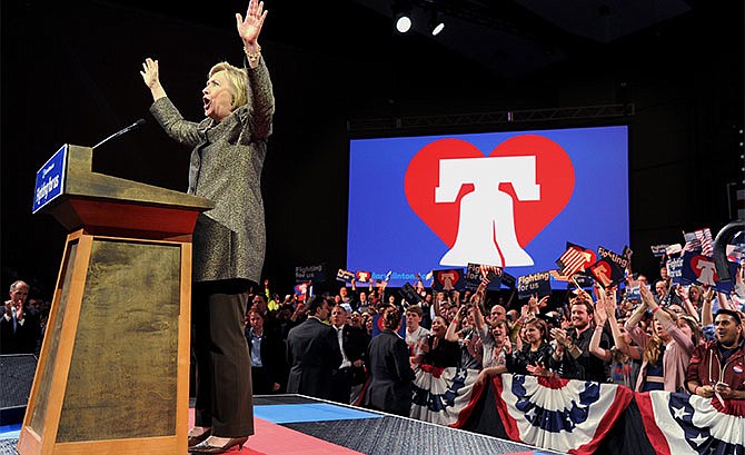 Democratic presidential candidate Hillary Clinton raises her arms onstage at her victory party at the Philadelphia Convention Center on Tuesday, April 26, 2016. Her husband, former president Bill Clinton is at lower left. (Tom Gralish/The Philadelphia Inquirer via AP)
