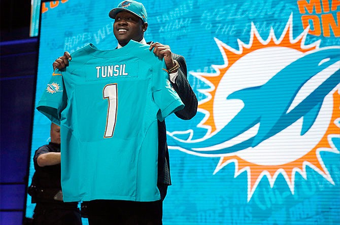 Mississippiâ€™s Laremy Tunsil poses for photos after being selected by the Miami Dolphins as the 13th pick in the first round of the 2016 NFL football draft, Thursday, April 28, 2016, in Chicago.