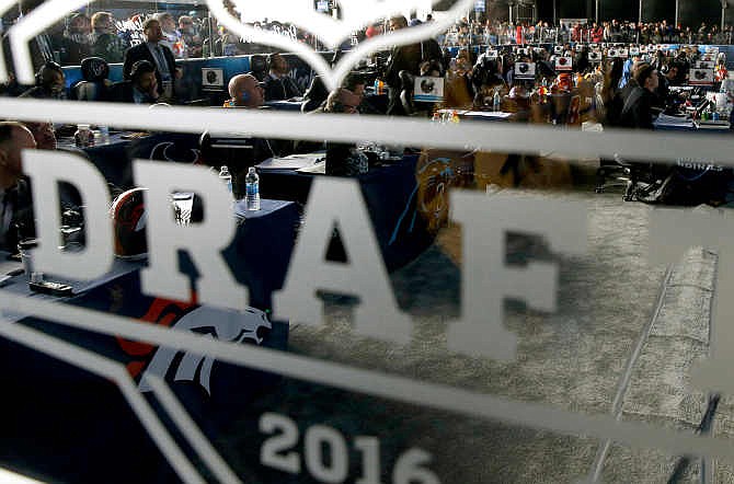 Representatives from NFL football teams work during the last day of the 2016 NFL Draft on Saturday, April 30, 2016, in Chicago.