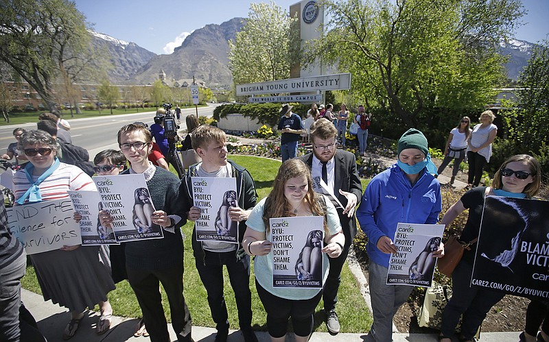 This April 20, 2016, file photo, Protesters stand in solidarity with rape victims on the campus of Brigham Young University during a sexual assault awareness demonstration, in Provo, Utah. Several Utah police officials are joining in calls to change Brigham Young University's practice of investigating students who have reported being sexually assaulted for violations of the school's strict code of behavior. 