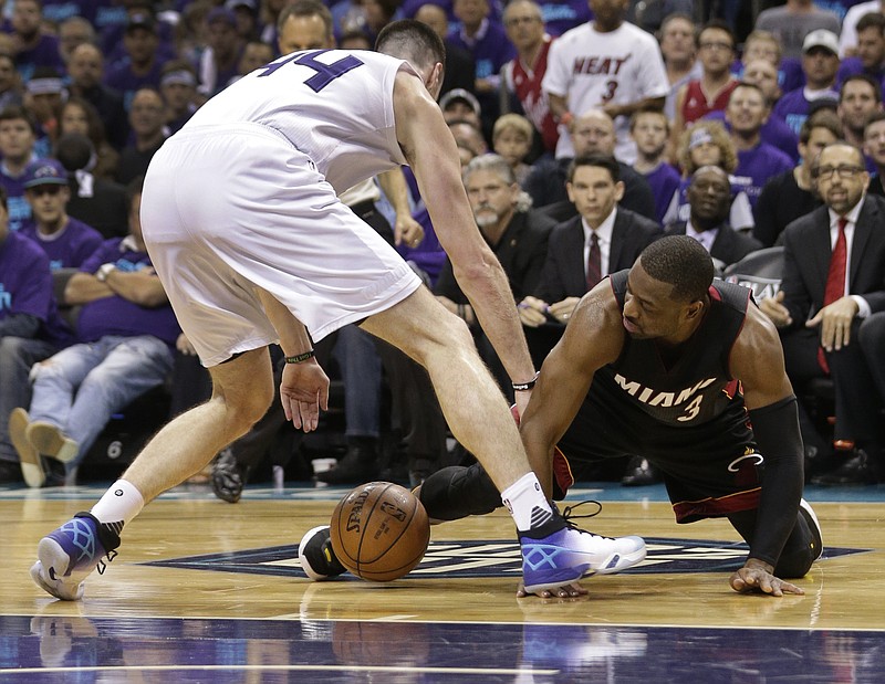 Miami Heat's Dwyane Wade, right, and Charlotte Hornets' Frank Kaminsky, left, scramble for a loose ball during the first half in Game 6 of an NBA basketball playoffs first-round series in Charlotte, N.C., Friday, April 29, 2016.