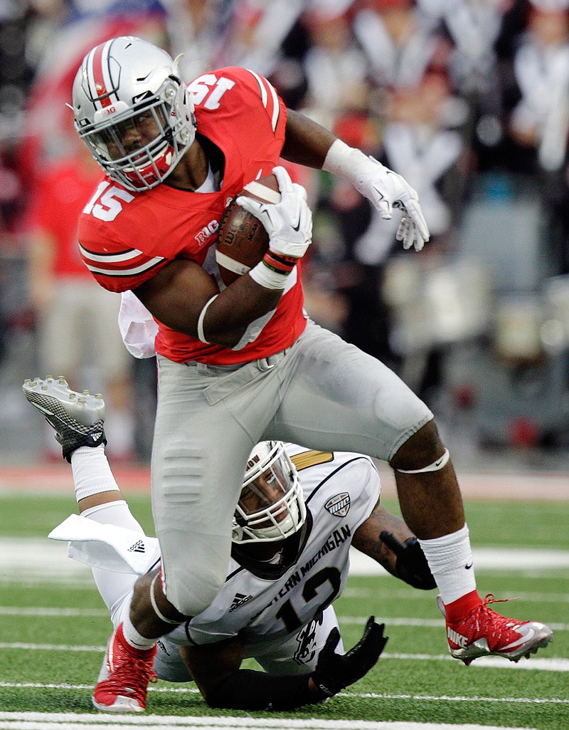 In this Sept. 26, 2015, file photo, Ohio State running back Ezekiel Elliott escapes the grasp of Western Michigan defensive end Kelon Adams during the fourth quarter of an NCAA college football game in Columbus, Ohio. Elliott is one of the top offensive players available in the NFL Draft, which starts April 28 in Chicago. 