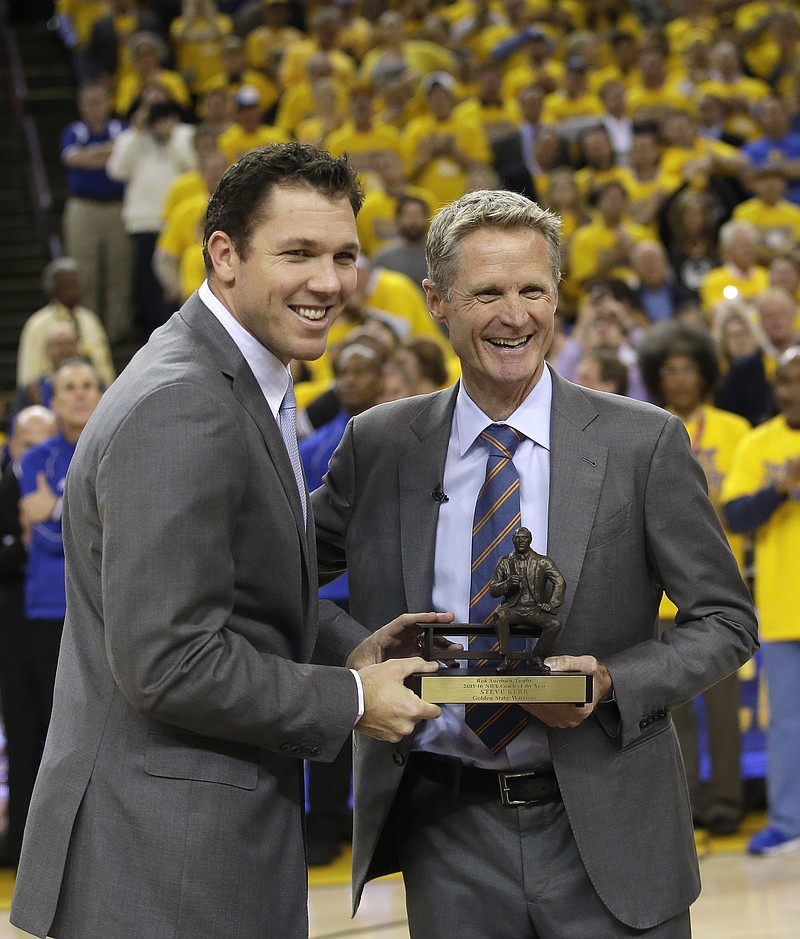 Golden State Warriors head coach Steve Kerr, right, poses for a photo with the league's coach of the year trophy alongside assistant coach Luke Walton before Game 5 of a first-round NBA basketball playoff series Wednesday, April 27, 2016, in Oakland, Calif. 