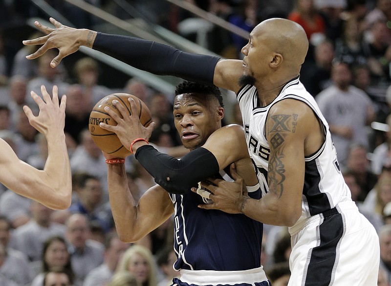 Oklahoma City Thunder guard Russell Westbrook, left, is pressured by San Antonio Spurs forward David West, right, during the first half in Game 1 of a second-round NBA basketball playoff series, Saturday, April 30, 2016, in San Antonio. 