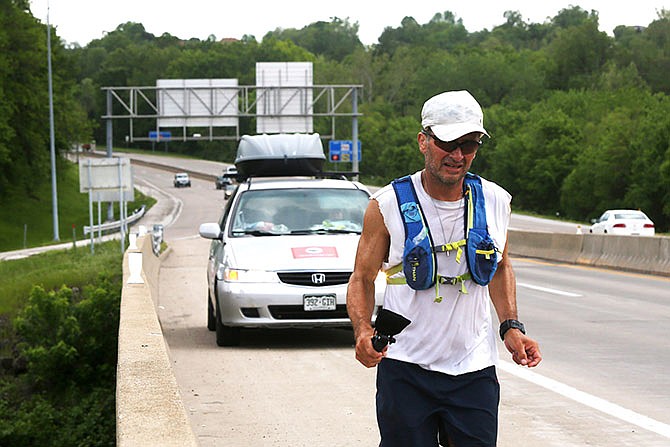Jason Romero runs along U.S. 54 in Jefferson City as he makes his ultra-marathon trip Saturday from Los Angeles to Boston. Romero, who is expected to trek through Callaway County today, reportedly will become the first blind person to run across the U.S. when he finishes the marathon.
