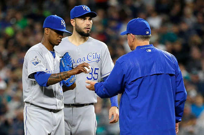 Kansas City Royals starting pitcher Yordano Ventura, left, is pulled during the fifth inning of the Royals' baseball game against the Seattle Mariners by manager Ned Yost, right, as first baseman Eric Hosmer, center, waits, Saturday, April 30, 2016, in Seattle.