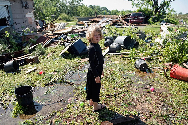 Memphis Melton, 7, looks at the destruction in his aunt's backyard in Lindale, Texas Saturday, April 30, 2016. A suspected tornado came through the area Friday night. 