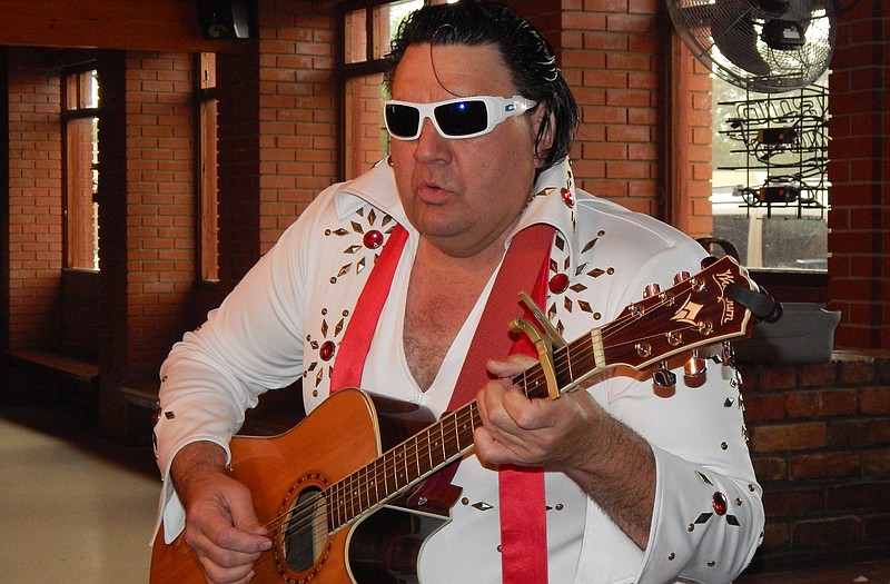 Dan G. Smith of Williamsburg plays a little Elvis on his Washburn guitar Monday at a private gathering in Fulton. He will film his latest video starting at 9 p.m. Saturday at 54 Country, 400 Gaylord Drive.