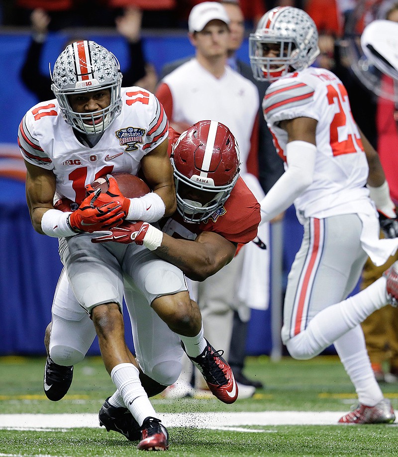 Ohio State defensive back Vonn Bell (11) is tackled by Alabama running back Jalston Fowler (45) after intercepting a pass in the second half of the Sugar Bowl NCAA college football playoff semifinal game, Thursday, Jan. 1, 2015, in New Orleans. 