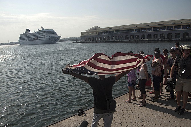 Daniel Miranda waves a U.S. flag as he watches the arrival of Carnivalâ€™s Adonia cruise ship from Miami on Monday in Havana, Cuba.