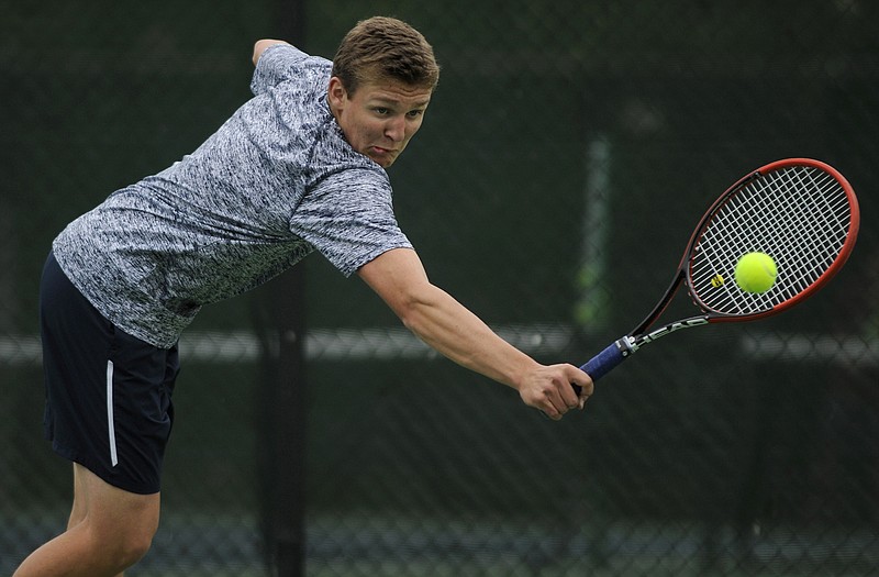 Heliasâ€™ T.J. Hagenhoff lunges to send a backhand return across the net while taking on School of the Osageâ€™s Jordan Wilson in the No. 1 singles match during Mondayâ€™s dual at Washington Park.