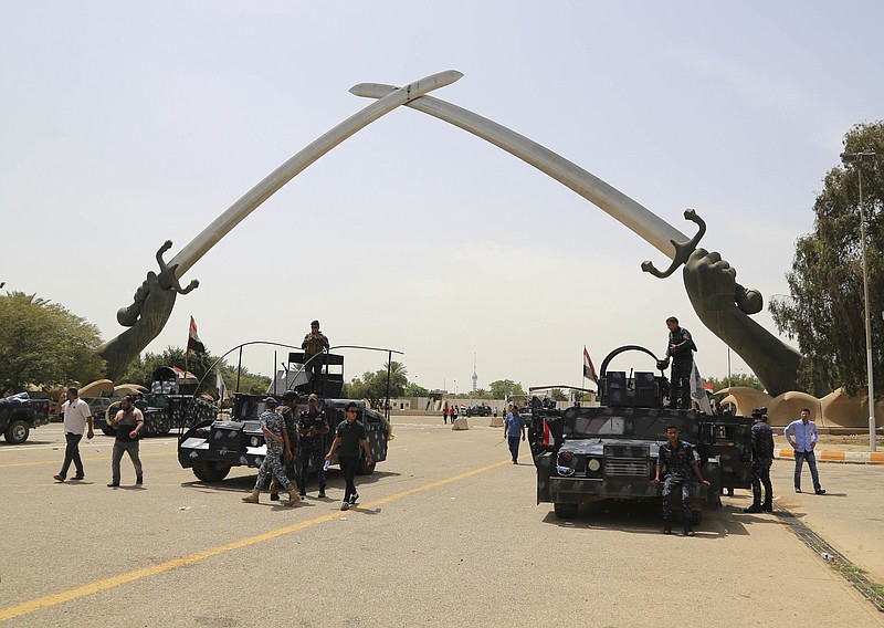 Iraqi security forces stand guard as supporters of Shiite cleric Muqtada al-Sadr leave Baghdad's highly fortified Green Zone Sunday, May 1, 2016. Anti-government protesters temporarily ended their mass demonstration in Baghdad's Green Zone on Sunday and began an orderly withdrawal a day after tearing down walls around the government district and invading parliament. 