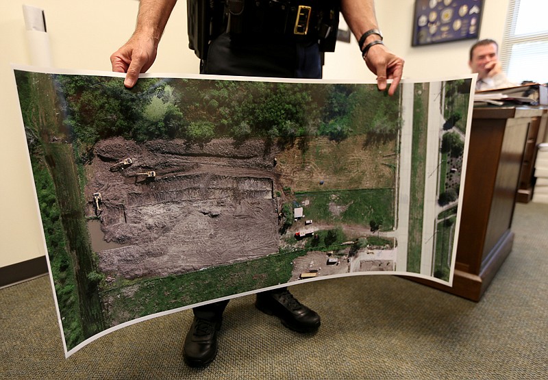 Friendswood police Chief Robert Wieners holds a large aerial photo on April 28 of the dig site on Orem Drive in Houston, where investigators found the remains of Jessica Cain in March. 
