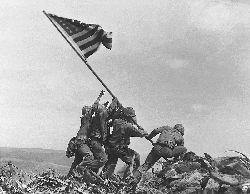 U.S. Marines of the 28th Regiment, 5th Division, raise the American flag atop Mount Suribachi on Feb 23, 1945, in  Iwo Jima, Japan. 