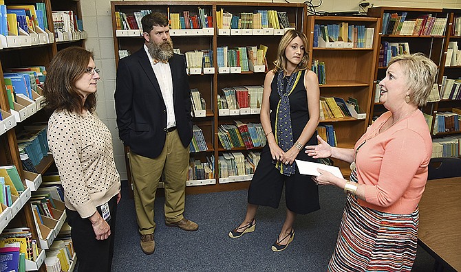 Anne Crowe, left, and Eric and Camille Weddle visit with Karen Enloe, of the Jefferson City Public Schools Foundation, on Tuesday in the reading recovery room at Lawson Elementary after delivering a check for $700 in memory of Nancy Gammon.