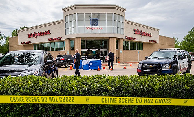 The body of a good samaritan lays under a blue tent after he was fatally shot outside a Walgreens on Monday, May 2, 2016, in Arlington, Texas, after he tried to stop a man who came to confront a woman who worked at the store. Arlington police say Anthony "T.J." Antell Jr. saw Ricci Bradden shoot at the feet of his wife during an argument Monday outside of the Walgreens where she works, striking her once. Antell retrieved a handgun from his vehicle and confronted Bradden in an attempt to make a citizen's arrest, but Bradden managed to slap it away and then fatally shot Antell, investigators say. 