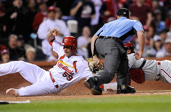 Eric Fryer of the Cardinals is safe at home on a single by Jedmys Diaz as Phillies catcher Carlos Ruiz makes a tag and umpire Quinn Wolcott makes the call during the fifth inning of Wednesday night's game at Busch Stadium.