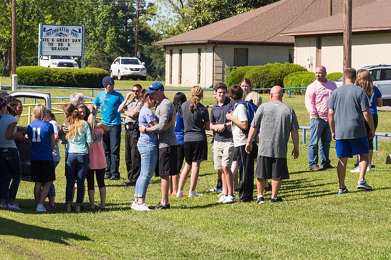 Redwater High students comfort one another after a white Toyota FJ Cruiser struck a student riding a bike Thursday, May 5, 2016 outside the school. Witnesses say the bicyclist ran out in front of the vehicle, which did not have the time or space to stop. The student was taken to the hospital with nonlife-threatening injuries.