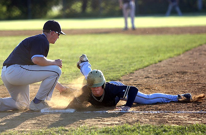 Zach Stiles of Helias dives back to first on a pickoff attempt during Thursday's game against St. Dominic at the American Legion Post 5 Sports Complex.