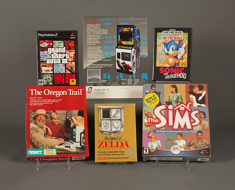 In this April 21, 2016 photo provided by The Strong museum in Rochester, N.Y., the 2016 inductees to the World Video Game Hall of Fame are displayed. From top left, clockwise, are "Grand Theft Auto III,"  "Space Invaders," "Sonic the Hedgehog," "The Sims," "The Legend of Zelda," and "The Oregon Trail." 