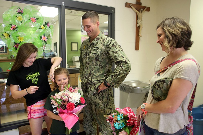 From left, Gracie, Aubrie, Brice and Katie Bernskoetter unite Friday at St. Martin Catholic School. Brice surprised his daughters with an early homecoming after being deployed for 11 months of service in the U.S. Navy.