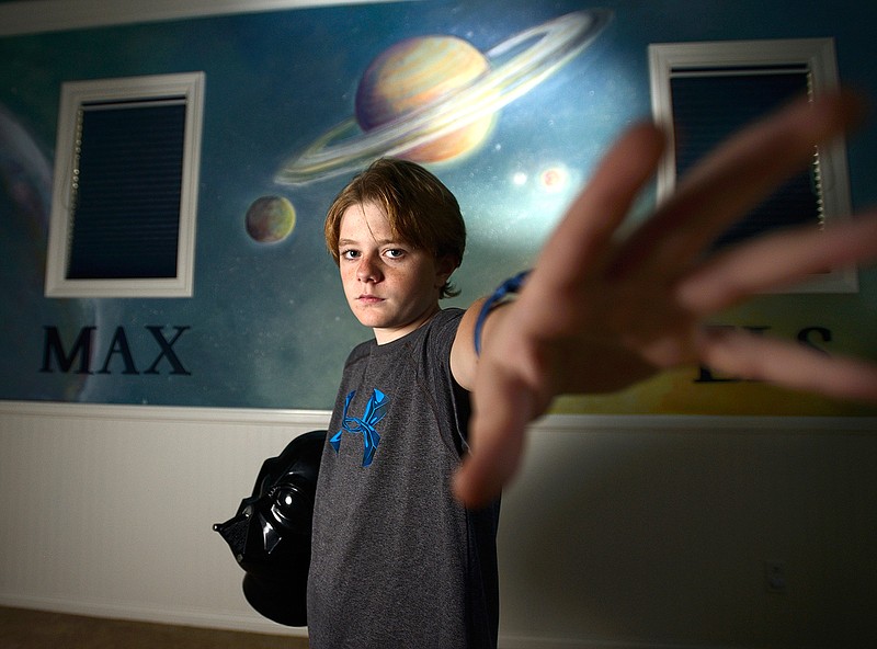 Actor Max Page, 11, holds on to an autographed Darth Vader helmet in his San Clemente, Calif., home on Thursday, Feb. 4, 2016. Page was the darling of the 2011 Super Bowl when he played Mini Darth Vader in a Volkswagen commercial. He's battled heart problems his whole life but continues to work as a child actor. 