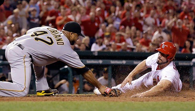 St. Louis Cardinals' Randal Grichuk, right, is safe at home as he scores on a wild pitch by Pittsburgh Pirates starting pitcher Francisco Liriano, left, during the seventh inning of a baseball game Friday, May 6, 2016, in St. Louis.