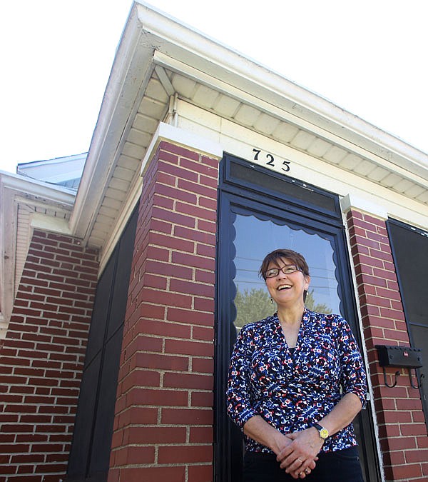 Suzanne Luther stands in front of 725 W. High St., the first installment of Four Quarters Art House, her new "social enterprise" venture. Luther founded Four Quarters Art House as a way to support local artists, as well as local charities by renovating old buildings in Jefferson City to turn a profit.