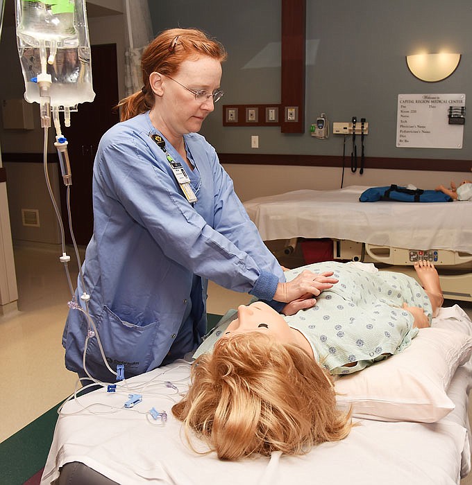 In this May 7, 2016 photo, Miriam Hardesty, a registered nurse in Capital Region's OB unit, practices the proper CPR technique on Noelle, the Jefferson City hospital's birthing simulation unit.