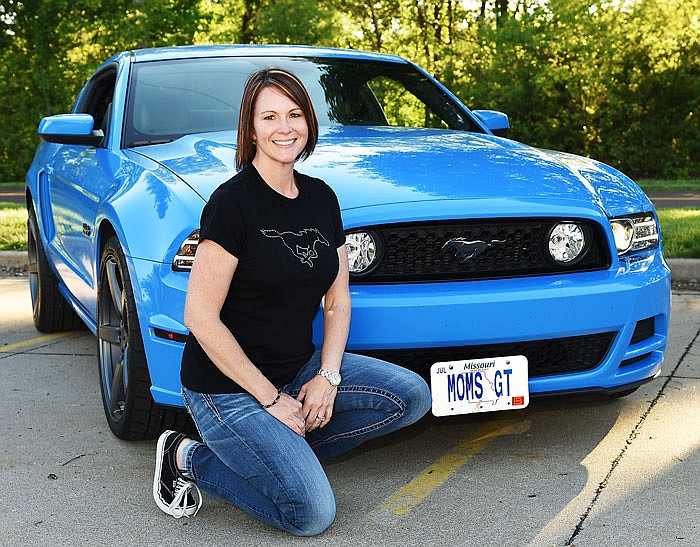 Regina Durr poses with her 2013 Grabber Blue Mustang. Durr is a Mustang enthusiast and participated in the Shelbyfest Country Cruise and had her vehicle on display Saturday, May 7, 2016 in downtown Jefferson City.