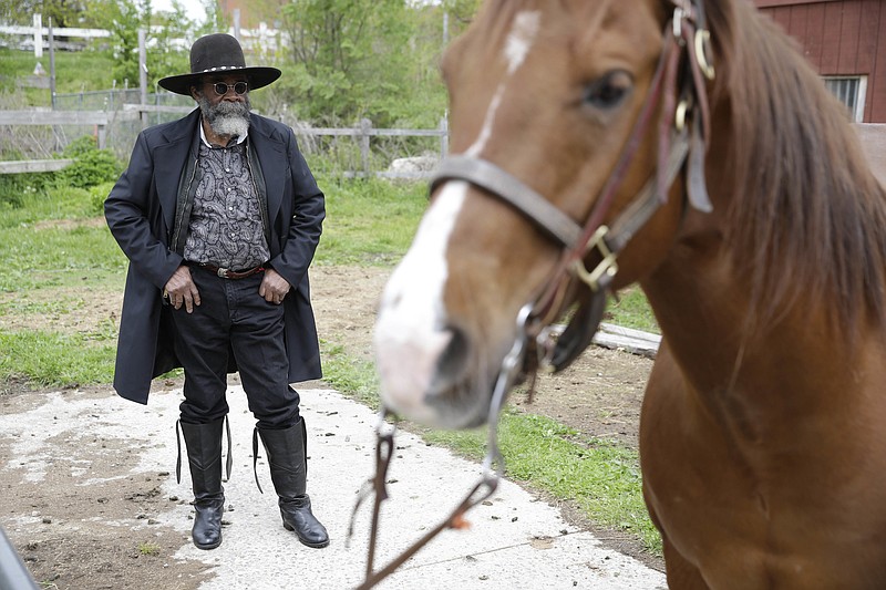 Ellis Harris, a member of the Federation of Black Cowboys, looks at a horse in the Queens borough of New York, Thursday, May 5, 2016.  For decades, members of the Federation of Black Cowboys have been an incongruous sight in New York City. When children see us with the fringe jackets and the boots, that stays with them for life, said Kesha Morse, the federations 67-year-old president.  But now, the federation is fighting to survive. 