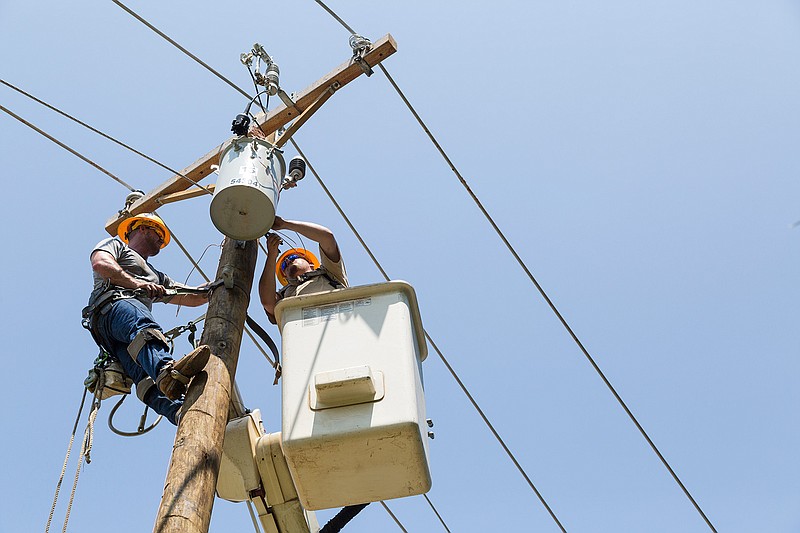 Bowie-Cass Electric Cooperative Kole Dillinger and Adam Balmain replace a transformer Tuesday, May 10, 2016, near Kings Highway. Work crews replaced damaged utility poles all day. 