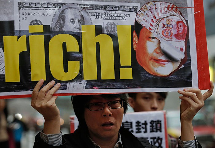 Protesters hold placards featuring portraits of Chinese President Xi Jinping and British Prime Minister David Cameron near the regional head office of Panama-based law firm Mossack Fonseca in Hong Kong, Tuesday, April 12, 2016 as they demand taxes on the rich. For Chinese President Xi Jinping, the Panama Papers showing his brother-in-law and relatives of two other members of the party's elite inner circle owned offshore companies, often referred to as tax havens, might be highly damaging. 