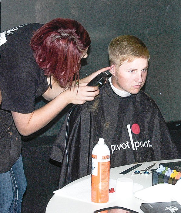 At the Moniteau County Resource Fair, local Merrell University student Rebecca Hamilton gives a haircut to Carter Asahl.