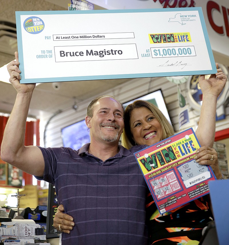 Bruce Magistro, left, and lottery representative Yolanda Vega pose for a picture during a news conference Wednesday in Babylon, N.Y. Magistro, who won $1 million in the New York Lottery for a second time, remembers thinking, "This is impossible."