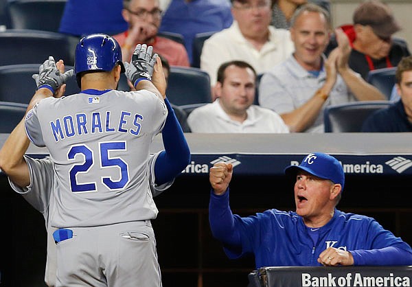 Kendrys Morales is greeted by a Royals teammate as manager Ned Yost reacts after Morales' solo home run in the seventh inning of Wednesday night's game against the Yankees in New York.
